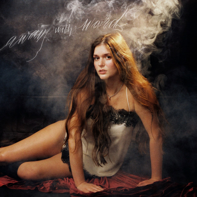 Away with words single cover — Delilah Brao seated on red velvet in swirling smoke